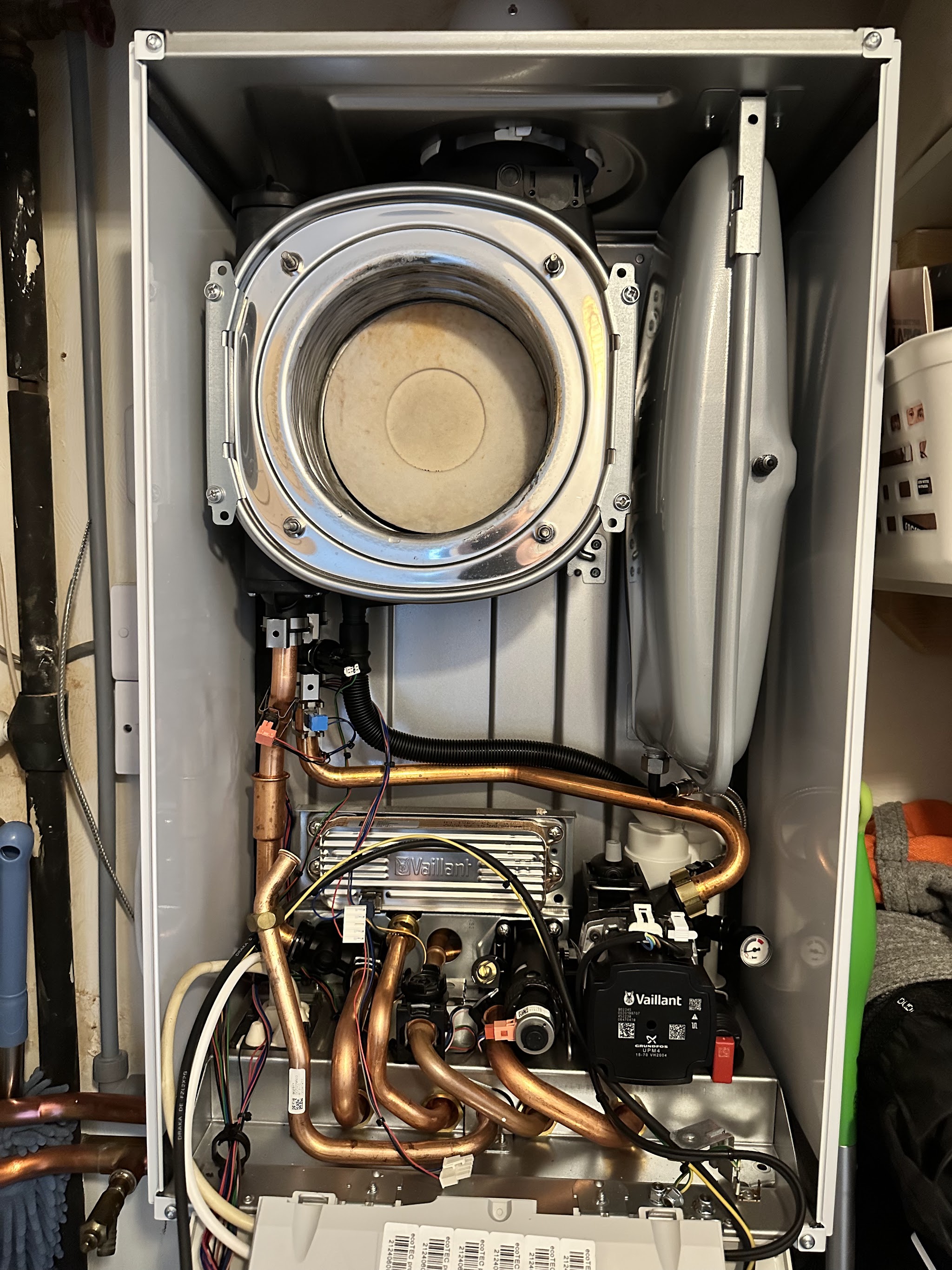 A boiler with its front cover off, showing the heat exchanger and internals