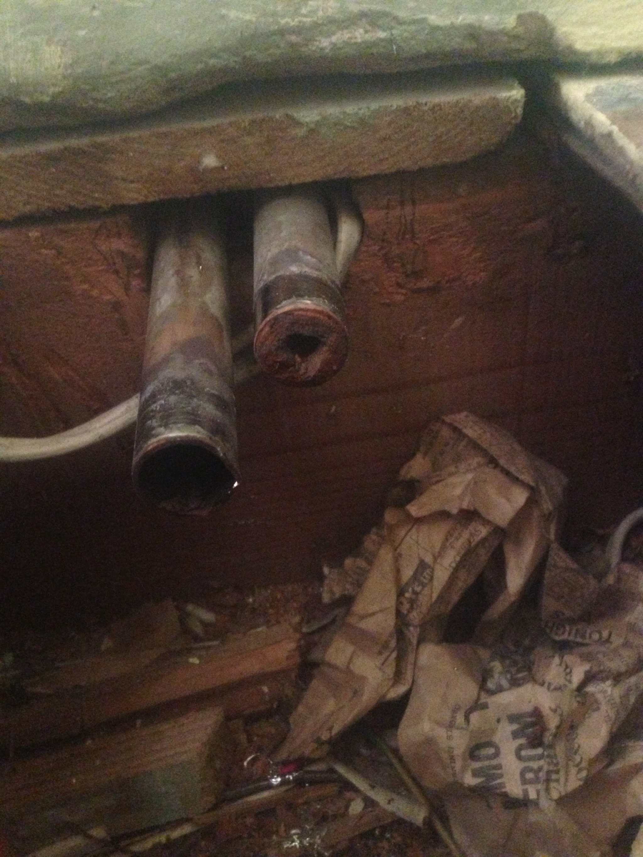 Corroded old pipes found under the floorboards on a repair job